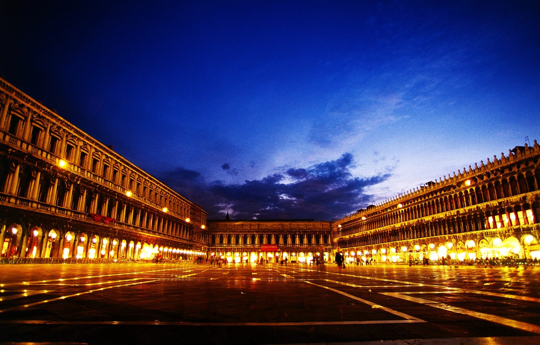 The arcaded Procuratie around St. Mark’s Square in Venice, lit up at dusk